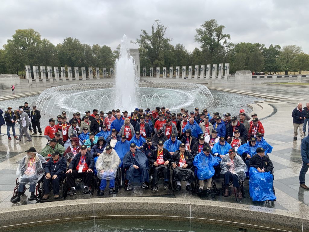 Group photo of all veterans in front of WWII Memorial 
