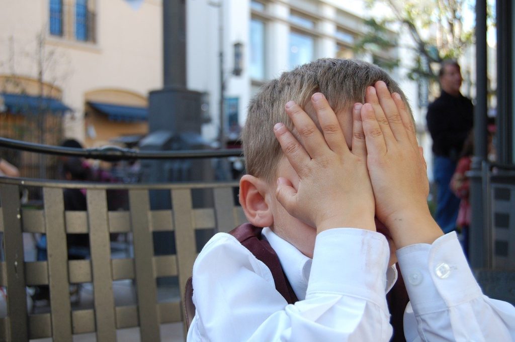 embarrassed boy in awkward situation facepalm