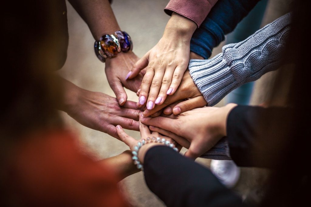 hands reaching in for each other together in group