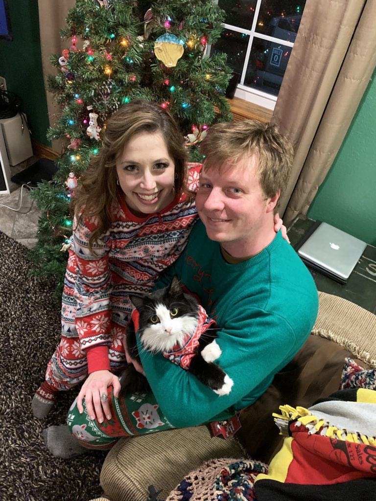 Moby at Christmas dressed up in pajamas in front of tree